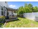 Serene backyard featuring a covered patio, lush lawn, and white picket fence, perfect for outdoor living at 191 Enterprise Dr, Clayton, NC 27520