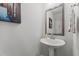 Simple powder room featuring a pedestal sink, modern mirror, and neutral decor at 191 Enterprise Dr, Clayton, NC 27520