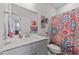 Well-lit bathroom with a modern vanity, decorative shower curtain, and neutral decor at 191 Enterprise Dr, Clayton, NC 27520