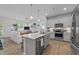 Open-concept kitchen with a center island, stainless steel appliances, and wood laminate flooring at 191 Enterprise Dr, Clayton, NC 27520