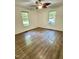 Empty bedroom featuring luxury vinyl plank flooring, two large windows, and a ceiling fan at 192 Misty Hollow Rd, Timberlake, NC 27583