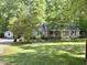Home exterior featuring a well-manicured lawn with a house, garage, and driveway at 192 Misty Hollow Rd, Timberlake, NC 27583