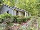 Charming home exterior showcasing a beautifully landscaped front yard with mature flowering plants at 192 Misty Hollow Rd, Timberlake, NC 27583