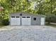 Exterior shot of a two-car garage with white doors, gray siding, and concrete parking pad at 192 Misty Hollow Rd, Timberlake, NC 27583