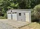 Exterior view of the garage featuring two bays, additional door, concrete pad, and gravel drive at 192 Misty Hollow Rd, Timberlake, NC 27583