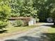View of the garage and a small shed, set amongst green trees and manicured lawn at 192 Misty Hollow Rd, Timberlake, NC 27583