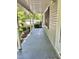 Long, covered porch featuring gray painted concrete and dark shutters against the siding at 192 Misty Hollow Rd, Timberlake, NC 27583
