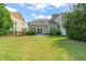 Enjoy outdoor living in this backyard with a patio, grassy lawn and privacy shrubs at 201 Mayfield Dr, Apex, NC 27539