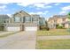 Inviting home with a two-car garage, stone accents, and beautiful green and gray color palette at 201 Mayfield Dr, Apex, NC 27539