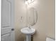 A powder room contains a decorative mirror, vanity with storage, and a neutral color palette at 201 Mayfield Dr, Apex, NC 27539