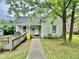 View of the home's exterior with accessible ramp, front door, and gray siding under a cloudy sky at 211 Webb St, Roxboro, NC 27573