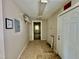 Hallway with white walls and tile flooring, leading to an exit door, and an electrical panel at 211 Webb St, Roxboro, NC 27573