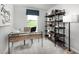 Bright home office featuring a modern glass desk, stylish shelving, and a large window offering a peaceful workspace at 254 Elyse Overlook Loop, Sanford, NC 27332