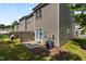 Backyard with patio, double doors, and AC unit set in a row of similar townhomes at 2713 Wyntercrest Ln, Durham, NC 27713