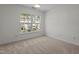 Empty bedroom with neutral carpeting and a large window overlooking the community at 2713 Wyntercrest Ln, Durham, NC 27713