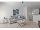 Neutral living room with a gray couch, side tables, and view of the hallway at 2713 Wyntercrest Ln, Durham, NC 27713