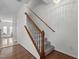 Carpeted stairs with a white and wood banister and decorative chandelier at 2713 Wyntercrest Ln, Durham, NC 27713