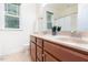 Well-lit bathroom features dual sinks, tile floors, a large mirror, and a window with natural light at 275 N Farm Dr, Clayton, NC 27527