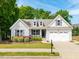 Charming one-story home featuring a landscaped yard and a two-car garage at 275 N Farm Dr, Clayton, NC 27527