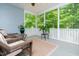 Inviting screened porch with wicker furniture and serene views of lush greenery, perfect for relaxing outdoors at 275 N Farm Dr, Clayton, NC 27527