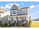 Charming two-story home featuring a welcoming front porch with stone accents and beautifully landscaped yard at 2919 Winter Crop Way, Apex, NC 27502