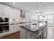 Bright kitchen features white cabinetry, stainless appliances, hardwood floors and stone countertops at 2919 Winter Crop Way, Apex, NC 27502