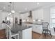 Bright kitchen features white cabinetry, stainless appliances, hardwood floors and stone countertops at 2919 Winter Crop Way, Apex, NC 27502