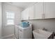 Bright laundry room with white cabinets, sink, and a washer-dryer set at 2919 Winter Crop Way, Apex, NC 27502