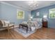 Serene blue bedroom with a chandelier, plush bedding, and lots of natural light at 3009 Hillmer Dr, Raleigh, NC 27609