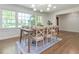 Bright dining area with large windows and a rustic wooden table set on a patterned rug at 3009 Hillmer Dr, Raleigh, NC 27609