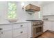 Stainless steel oven sits below a wooden hood in this well-lit kitchen with white cabinetry at 3009 Hillmer Dr, Raleigh, NC 27609