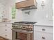 Close-up of a kitchen with stainless steel appliances, white subway tile, and white cabinets at 3009 Hillmer Dr, Raleigh, NC 27609