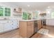 Bright kitchen with stainless steel appliances, light wood cabinets, an island and open shelving at 3009 Hillmer Dr, Raleigh, NC 27609