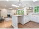 Bright eat-in kitchen has an island, bar seating, hardwood floors, and decorative shelves at 3009 Hillmer Dr, Raleigh, NC 27609
