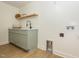 Laundry room with modern green cabinets, granite counters, open shelving, and connections for the washer and dryer at 3009 Hillmer Dr, Raleigh, NC 27609