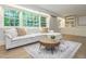 Spacious living room with large windows, comfortable seating, and built-in shelves for storage and decor at 3009 Hillmer Dr, Raleigh, NC 27609