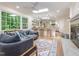 Open floor plan with living room leading to kitchen featuring a fireplace, skylights, and hardwood flooring at 3009 Hillmer Dr, Raleigh, NC 27609