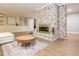 Modern living area with a painted brick fireplace, built-in shelving, and wood-look flooring at 3009 Hillmer Dr, Raleigh, NC 27609