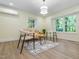Inviting living room with lots of light, a stylish accent rug, wood-look flooring, and ductless air conditioning unit at 3009 Hillmer Dr, Raleigh, NC 27609