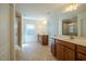 Bright bathroom featuring double vanities, tiled flooring, walk-in shower, and natural light from a large window at 311 Alamosa Pl, Cary, NC 27519