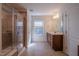 Bright bathroom with tiled flooring, double sink, and walk-in shower at 311 Alamosa Pl, Cary, NC 27519