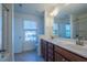 Bathroom with a double sink vanity, tiled floor and view of the backyard through a window above the toilet at 311 Alamosa Pl, Cary, NC 27519