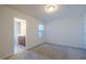 An empty bedroom with carpeted floors leads to an ensuite bath with a tiled floor and vanity at 311 Alamosa Pl, Cary, NC 27519