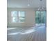 Bright living area with chandelier, large windows, and sliding door to backyard at 311 Alamosa Pl, Cary, NC 27519