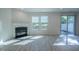 Bright living area featuring fireplace, large windows, and sliding door to backyard at 311 Alamosa Pl, Cary, NC 27519
