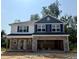 New construction with stone accents, blue shutters and siding under a clear, sunny sky at 327 Bishop Ln, Sanford, NC 27330