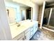 Bathroom featuring double sinks, white cabinets, a walk-in shower, and a soaking tub at 332 Bishop Ln, Sanford, NC 27330