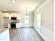 Dining area with modern lighting, kitchen access, and a window view at 332 Bishop Ln, Sanford, NC 27330
