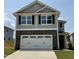 Charming two-story home with gray siding, stone accents, black shutters, and a spacious two-car garage at 332 Bishop Ln, Sanford, NC 27330