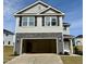 Two-story home with gray siding, black shutters, and stone accents over the garage at 332 Bishop Ln, Sanford, NC 27330
